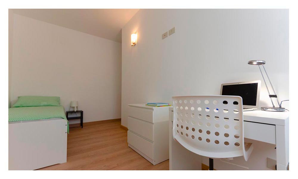 vista generale della stanza con letto singolo e scrivania per studio o lavoro