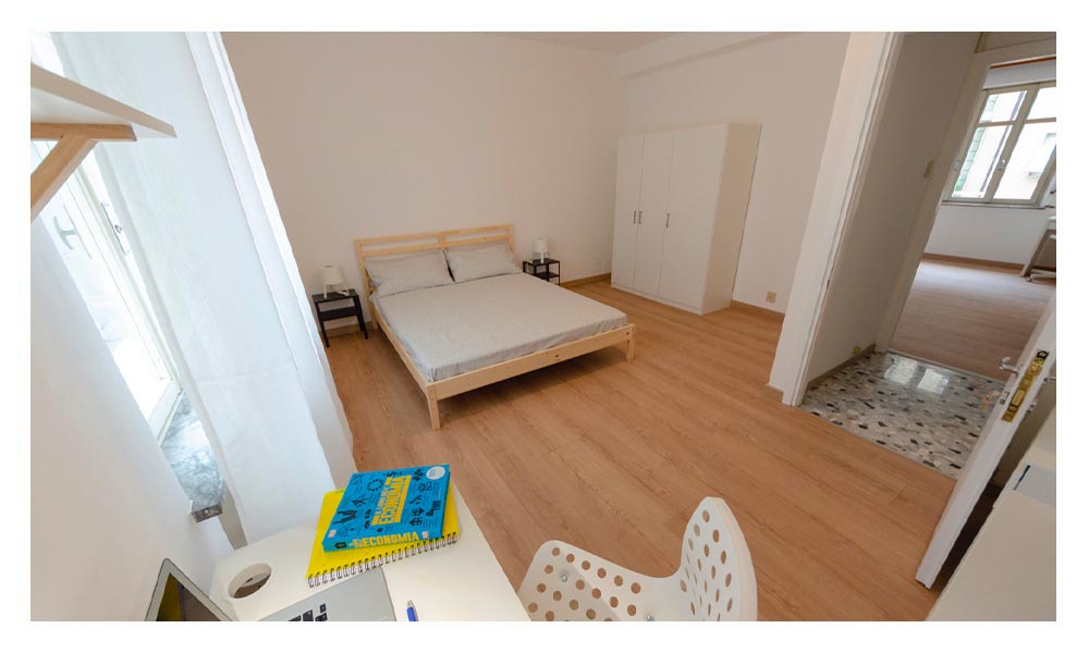 vista generale della stanza, con letto matrimoniale e area per lo studio o lavoro