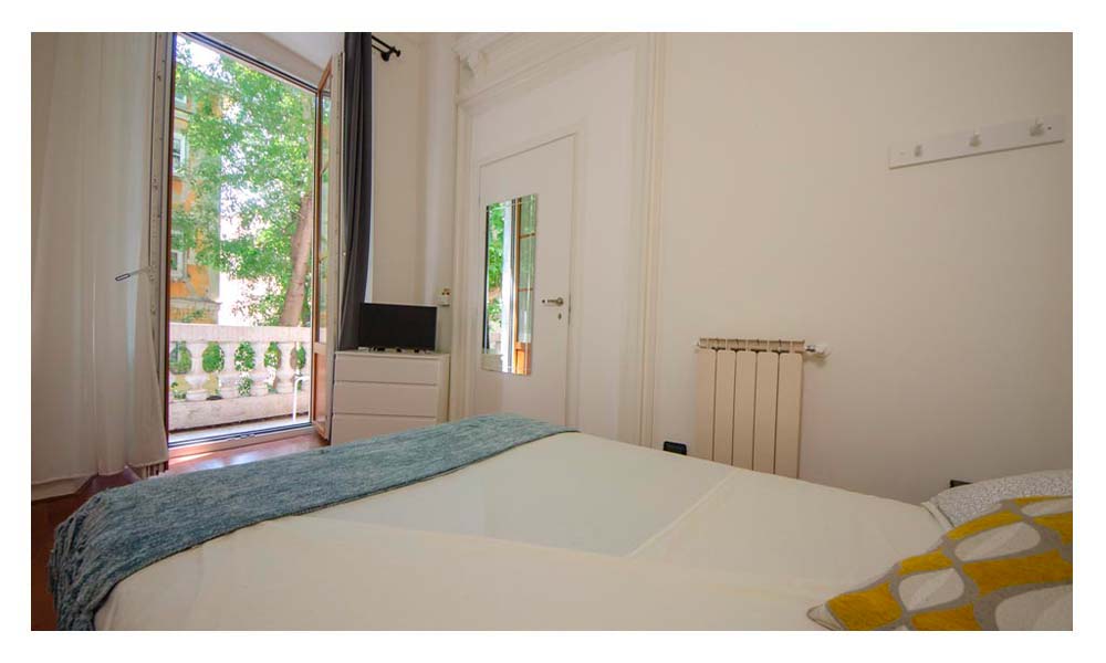 vista della stanza dal letto matrimoniale che punta sul balcone privato