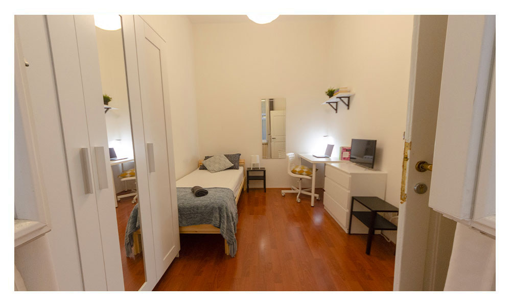 vista della stanza con letto singolo e armadio con specchio