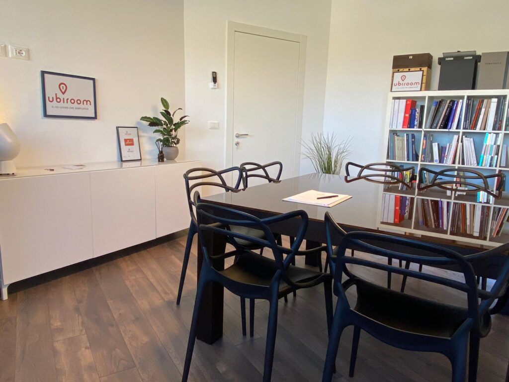 Sala riunioni moderna con arredi neri e libreria